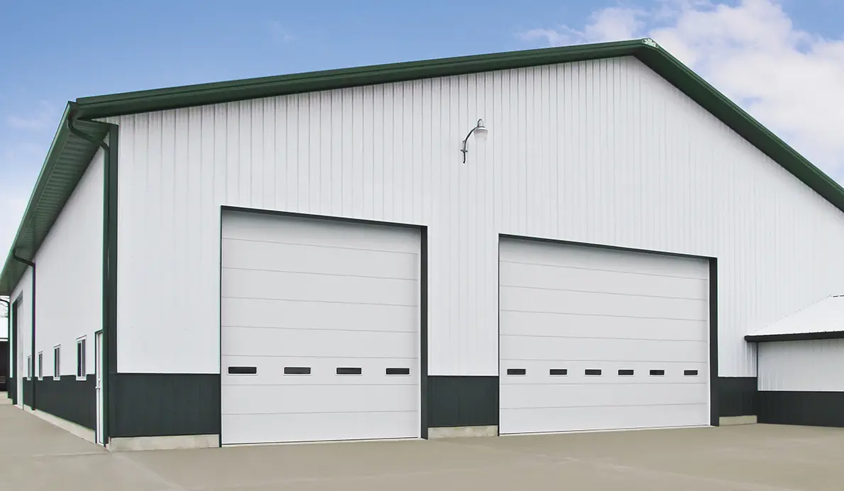 Large white industrial building with garage doors.