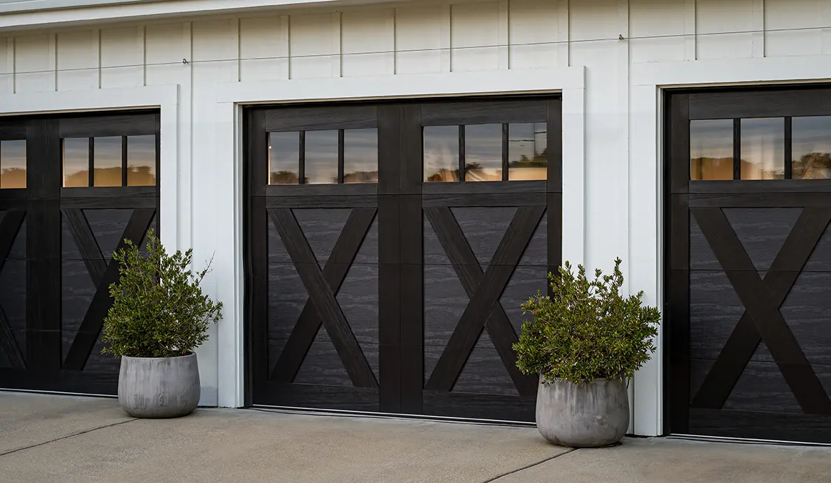 Modern garage doors with decorative plants.