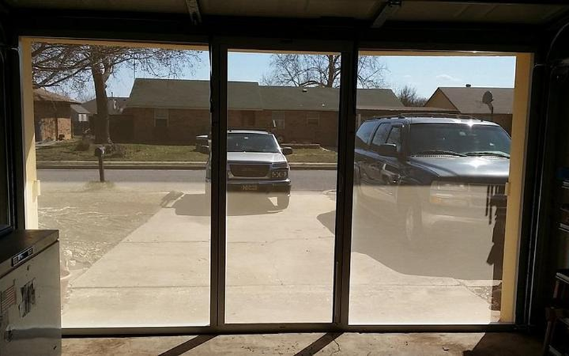 Garage door view of parked vehicles outside.